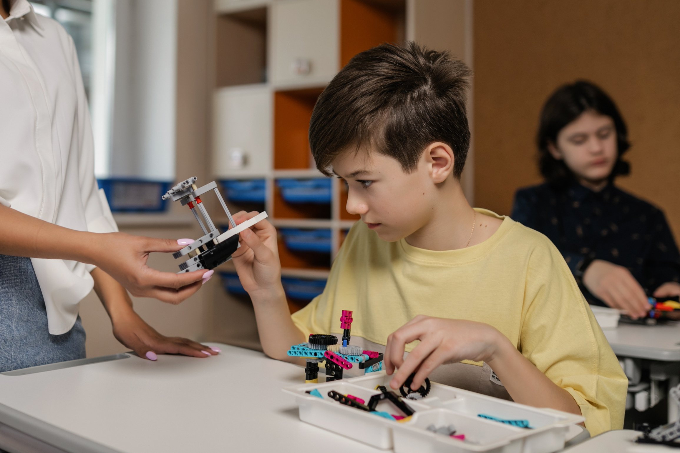 A  Boy in Yellow Crew Neck T-shirt Holding Holding Lego Piece